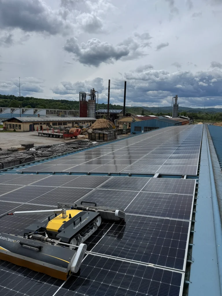 Robot čisti solarne panele na krovu industrijske zgrade