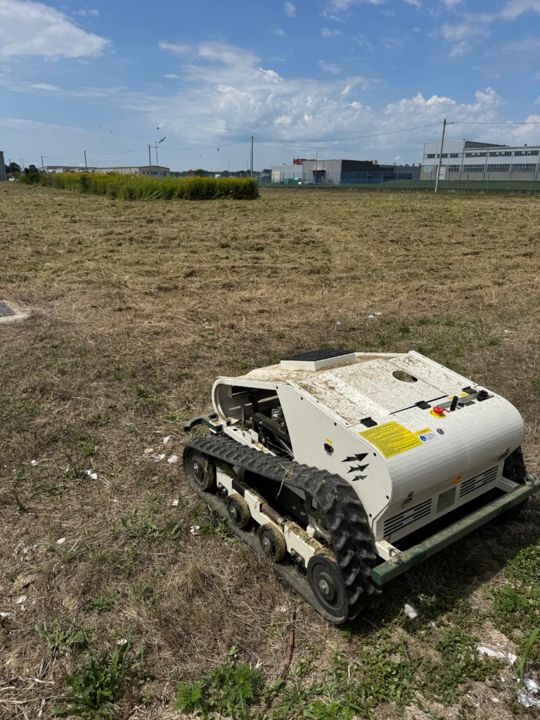 Robot kosilica na suhom polju kraj industrijske zone